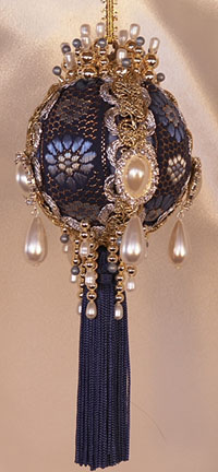 A gorgeous royal blue jacquard sets the tone for this blue and gold with dripping pearls Victorian Ornament