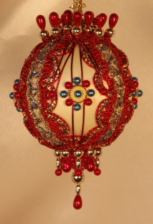 Mardi gras and circus colors stand out on this bright and festive red and teal Christmas ornament
